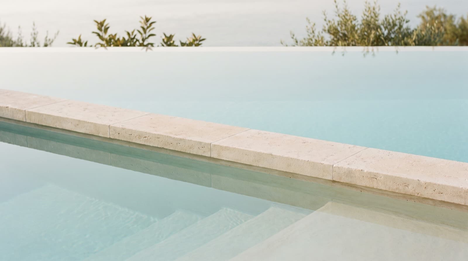 Calm water at the edge of an outdoor swimming pool.