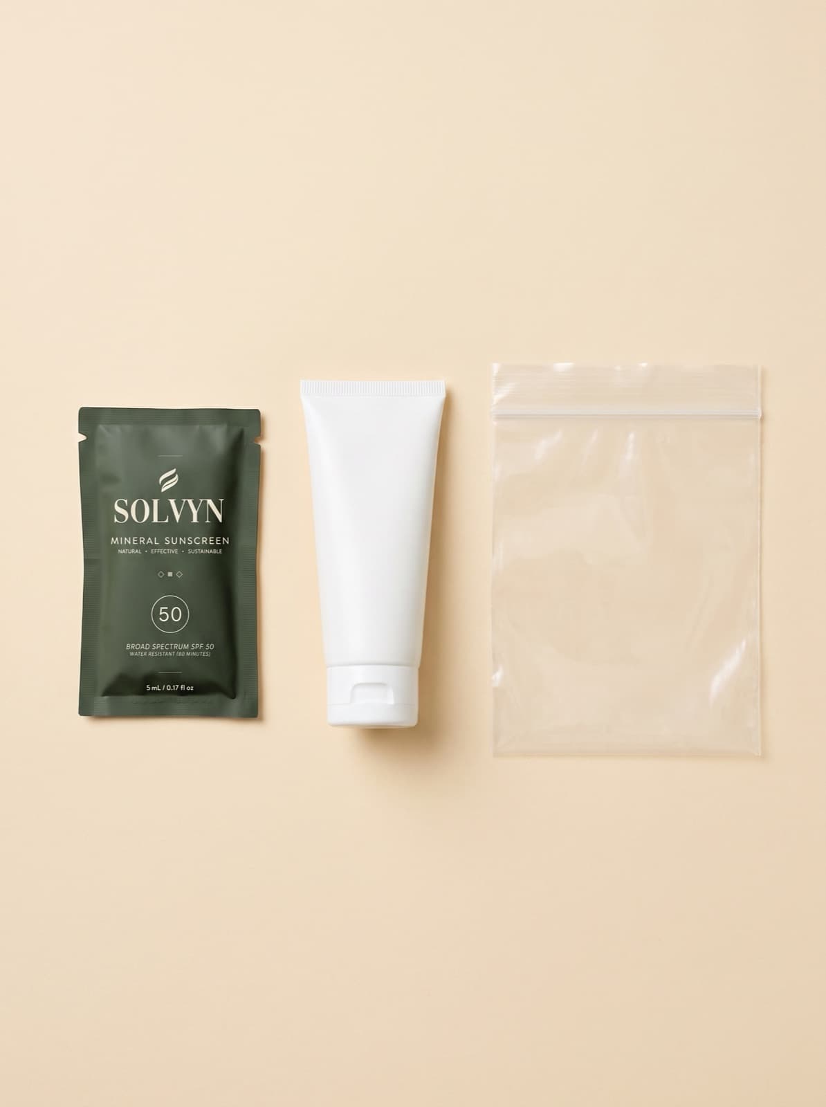 Size comparison, shot flat: a Solvyn Shield sachet beside a plain unbranded 3 oz tube and an empty quart travel bag — the sachet is by far the smallest