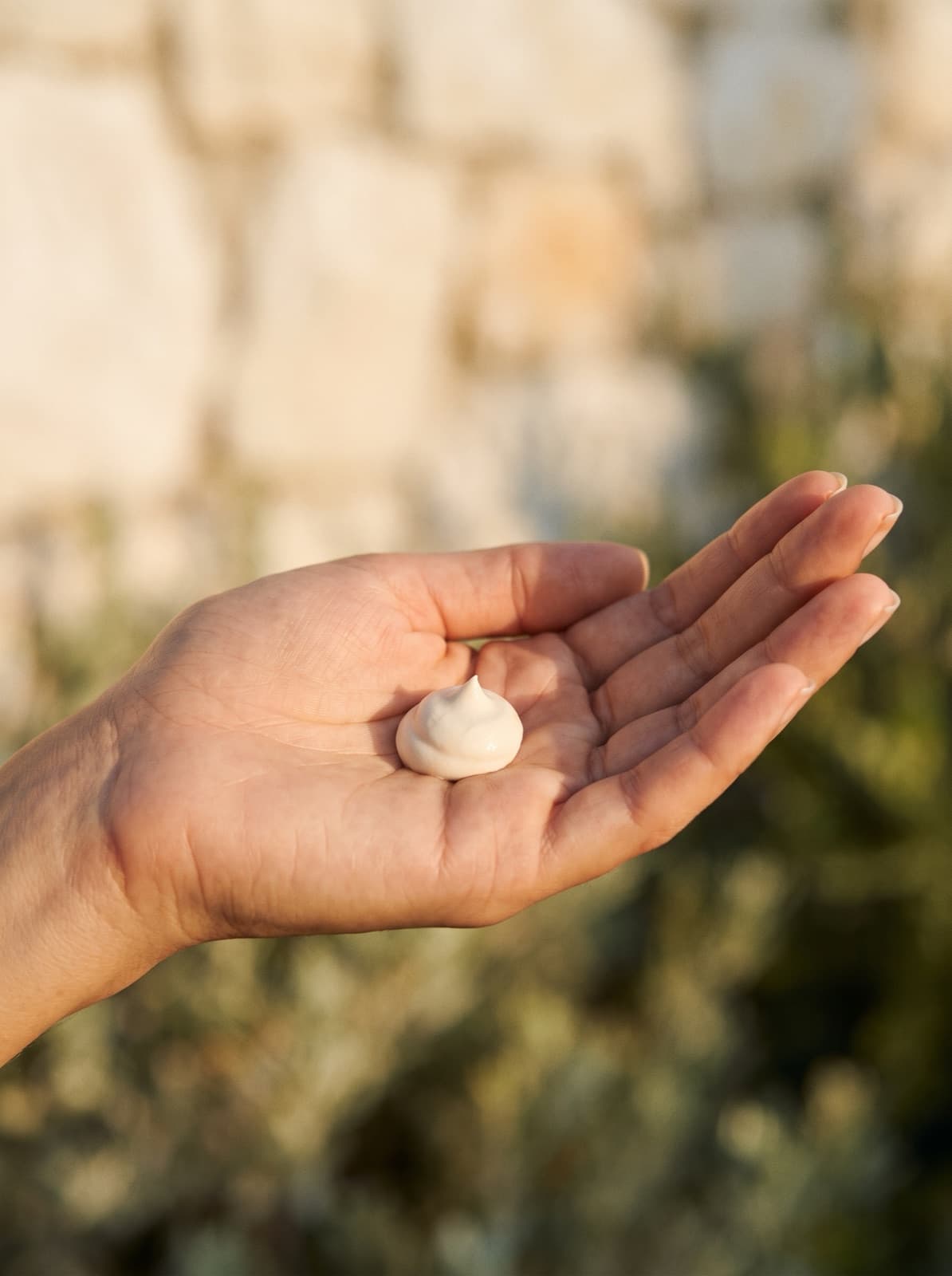 A pearl of white sunscreen in an open palm